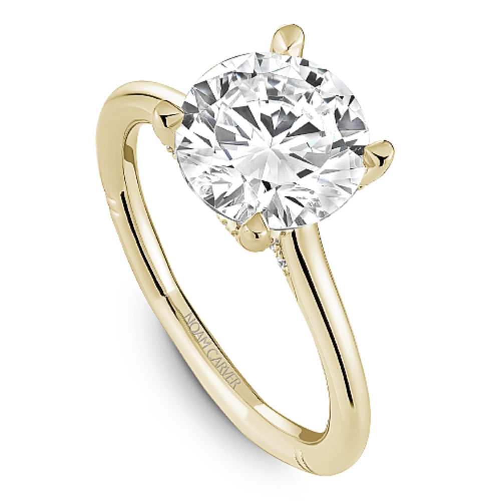 Gold Noam Carver ring with a large round diamond center on a white background