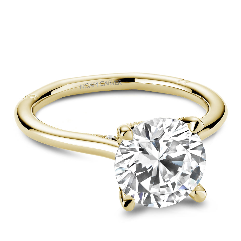 Gold Noam Carver ring with a large round diamond center on a white background
