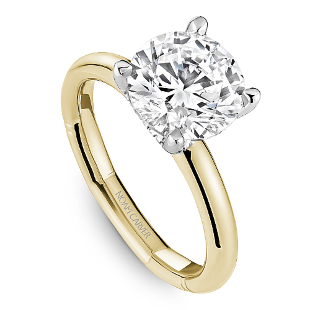 Gold Noam Carver ring with a round diamond center on a white background