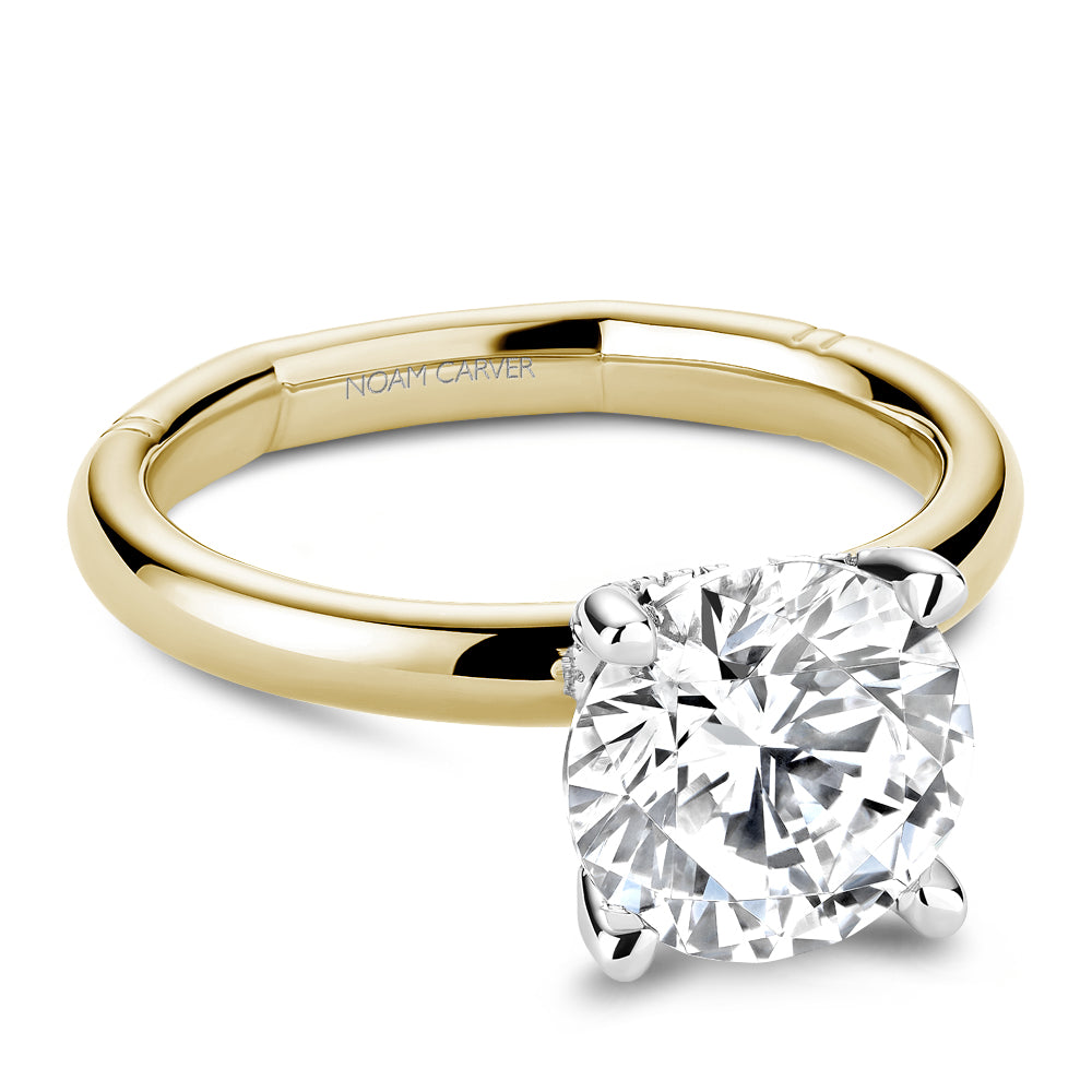 Gold Noam Carver ring with a round diamond center on a white background