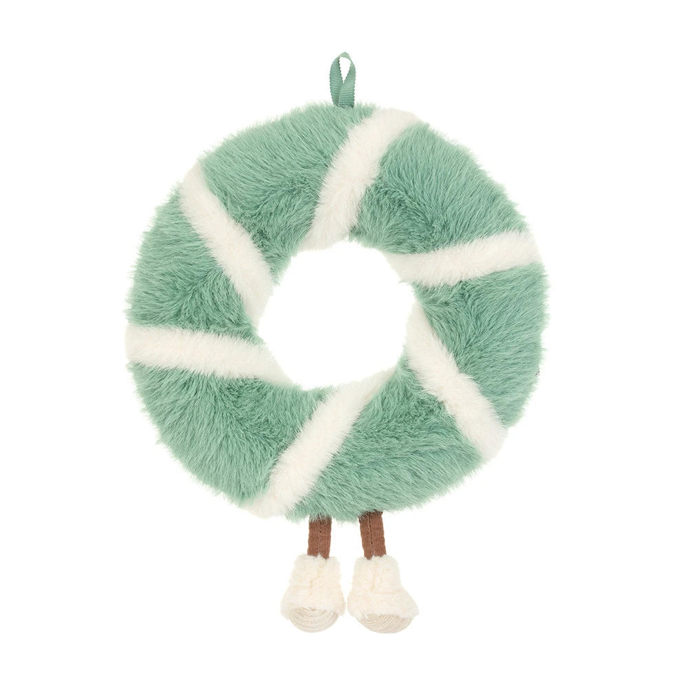 The back of a green and white striped wreath-shaped plush toy with acorn and pinecone details, a hanging loop, and small legs with white feet, shown on a plain white background.