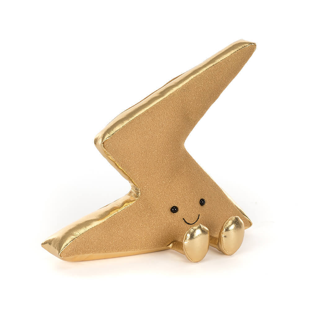 A side angled photo of a gold lightning bolt-shaped figurine plush toy with a smiling face and gold legs on a white background.