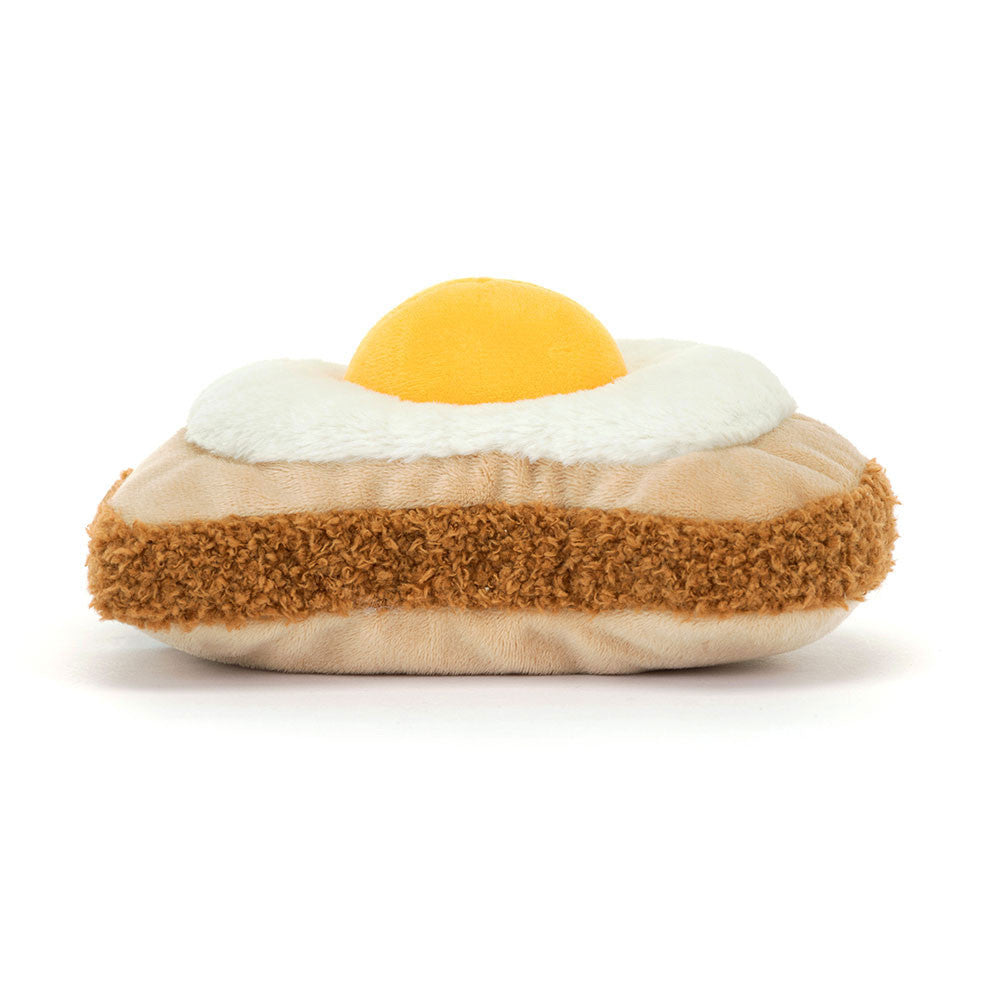 A back side photo of a plush toy resembling a egg on toast with a smiley face on a white background