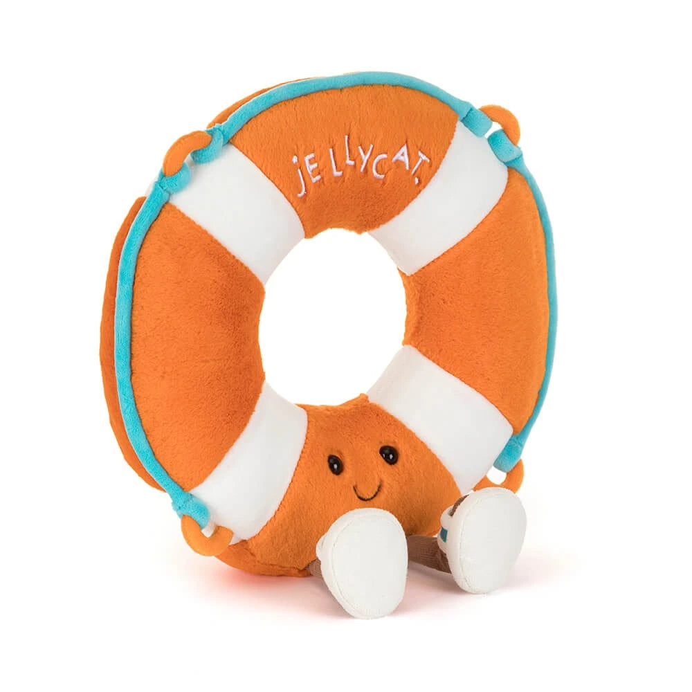 An angled side photo of a plush toy of a orange & white striped life ring that says "Jellycat" in white letters with a face and brown legs with white sandles on a white backround.
