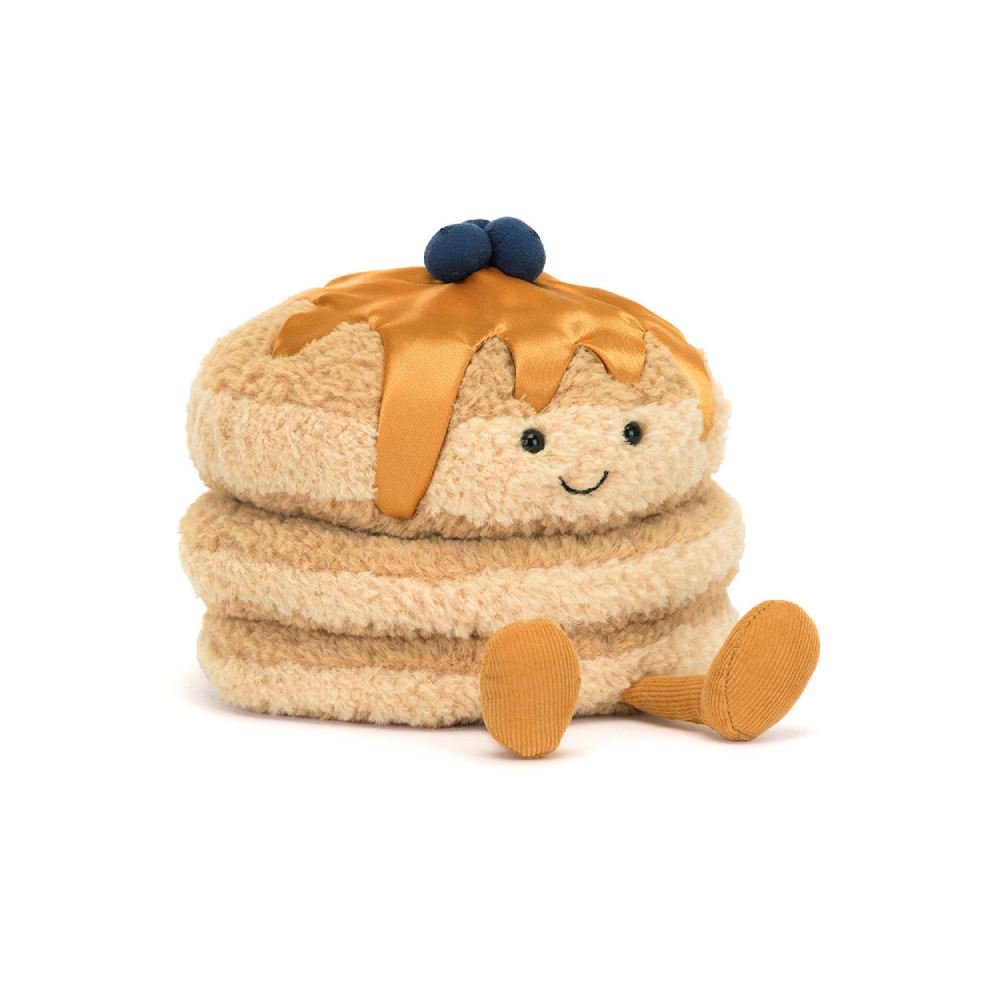 A plush toy resembling a stack of pancakes with syrup and blueberries on top, with a smiling face and corduroy legs.