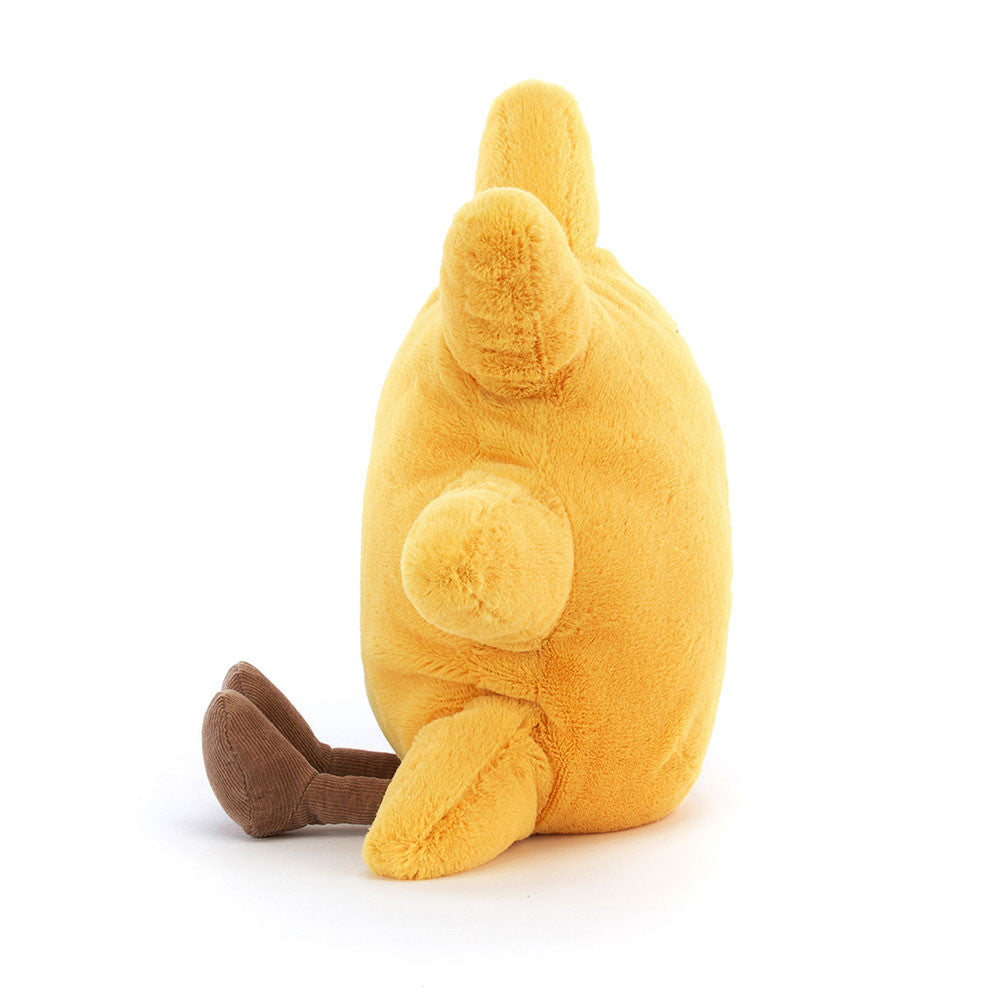 A side photo of a yellow plush sun toy with a smiling face and brown legs on a white background.