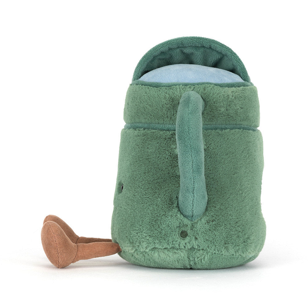 A side photo of a green plush toy watering can with a smiling face and brown legs on a white background.