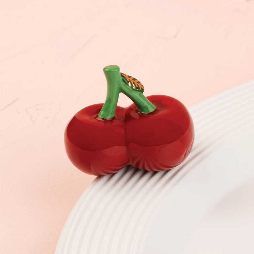 Red cherries mini on a textured white surface with a pink background.