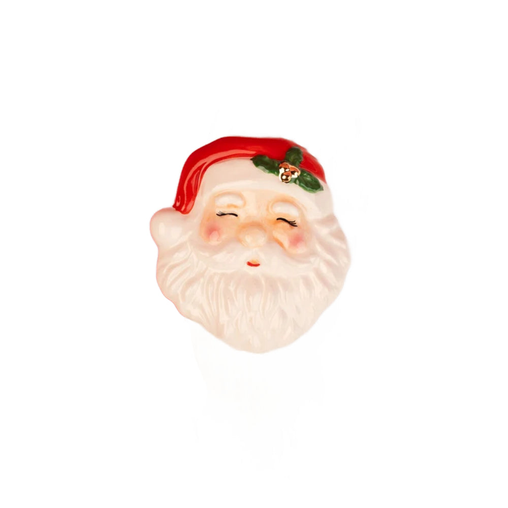 A small Santa Claus face charm or decorative figure with a red hat, green holly accent, and white beard on a plain white background.