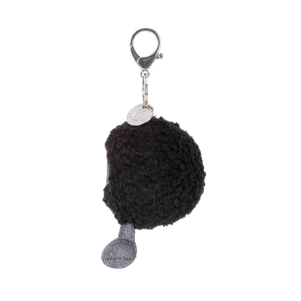 A side photo of a black hole plush keychain with a grey and black smiling face and grey legs on a white background.