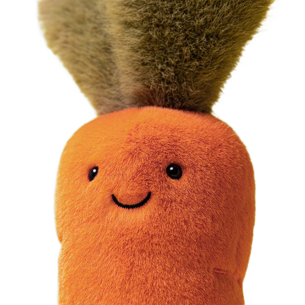 A close up photo of the face plush toy carrot with a smiling face on a white background.