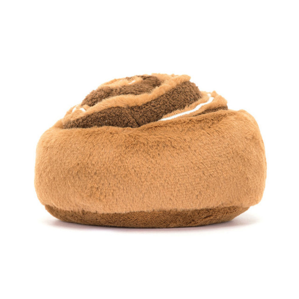 The back of a brown plush toy resembling a cinnamon bun with a happy facial expression, made from brown fur-like material with a cream-colored icing on top.