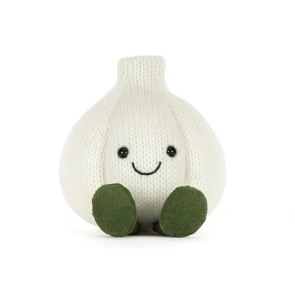 A knitted garlic character plush toy with a smiling face and olive green feet, photographed against a seamless white background.