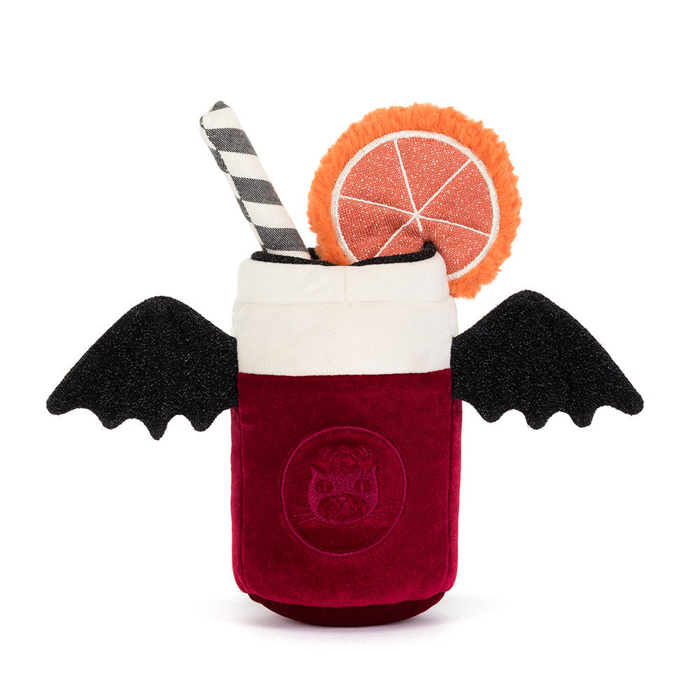 The back of a plush vampire cocktail cup toy on a white background, featuring a deep red body with a bat emblem, black wings, a white foam top, a black-and-white striped straw, and an orange slice garnish.