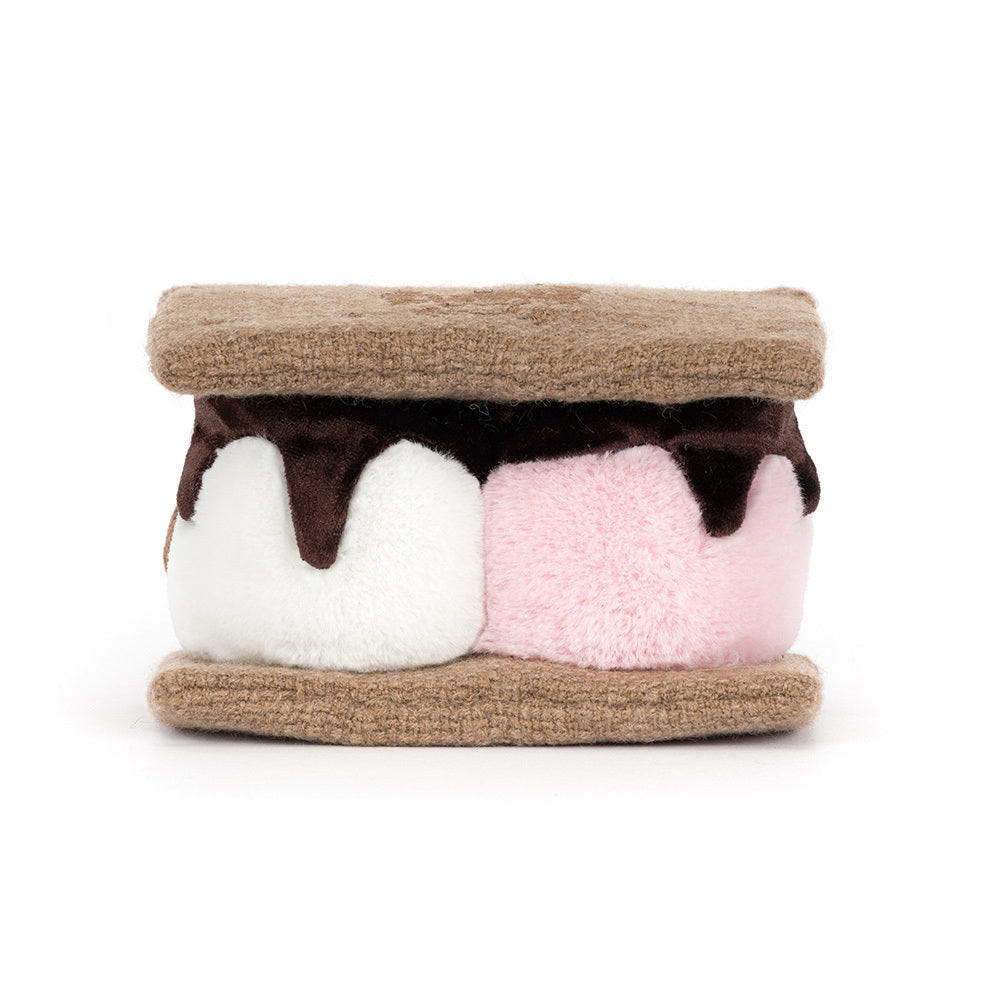 A  photo of the back of a plush toy resembling a s'more with brown gram cracker with pink and white marshmallows and chocolate on a white background.