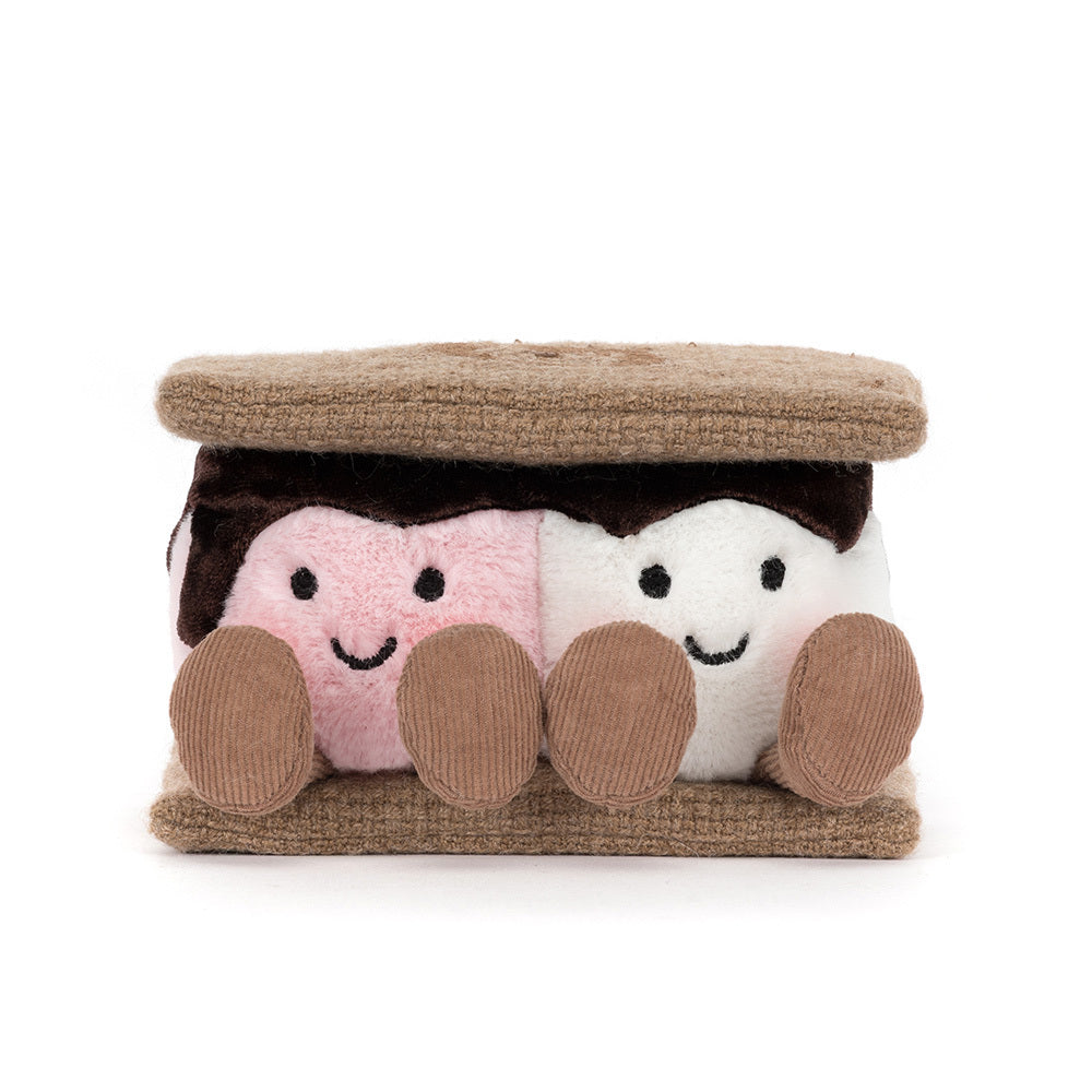 A front photo of a plush toy resembling a s'more with brown gram cracker with pink and white marshmallows and chocolate on a white background.