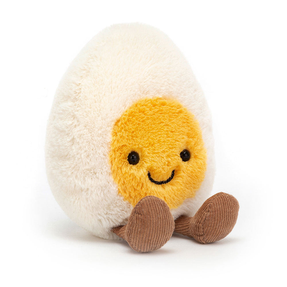 Plush toy resembling a boiled egg with a face expressing their happy face on a white background