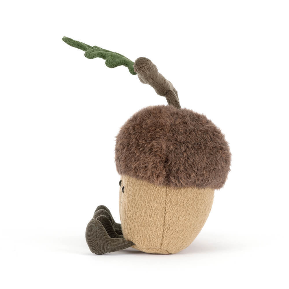 A side photo of a stuffed toy acorn with a branch on a white background.