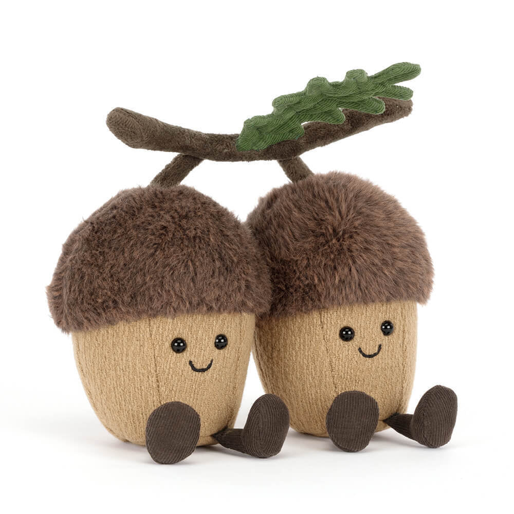 A side angled photo of a stuffed toy acorn with a branch on a white background.