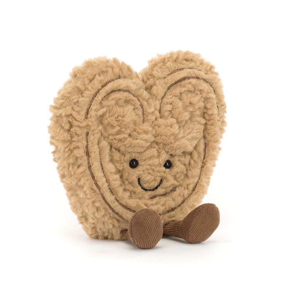 A angled photo of a brown heart-shaped plush toy with a smiling face on a white background.