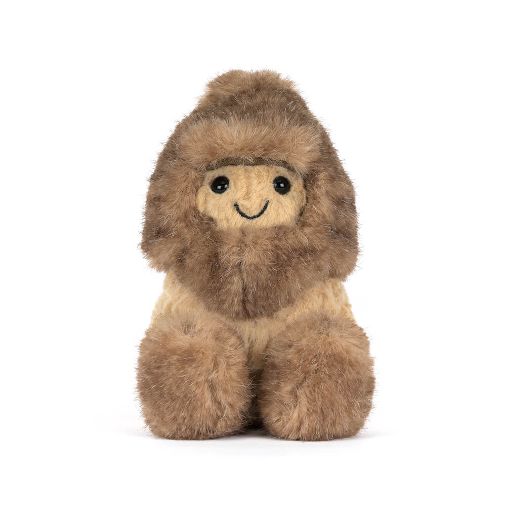 A front photo of a brown Peanut Yeti plush toy with a smiling face on a white background.