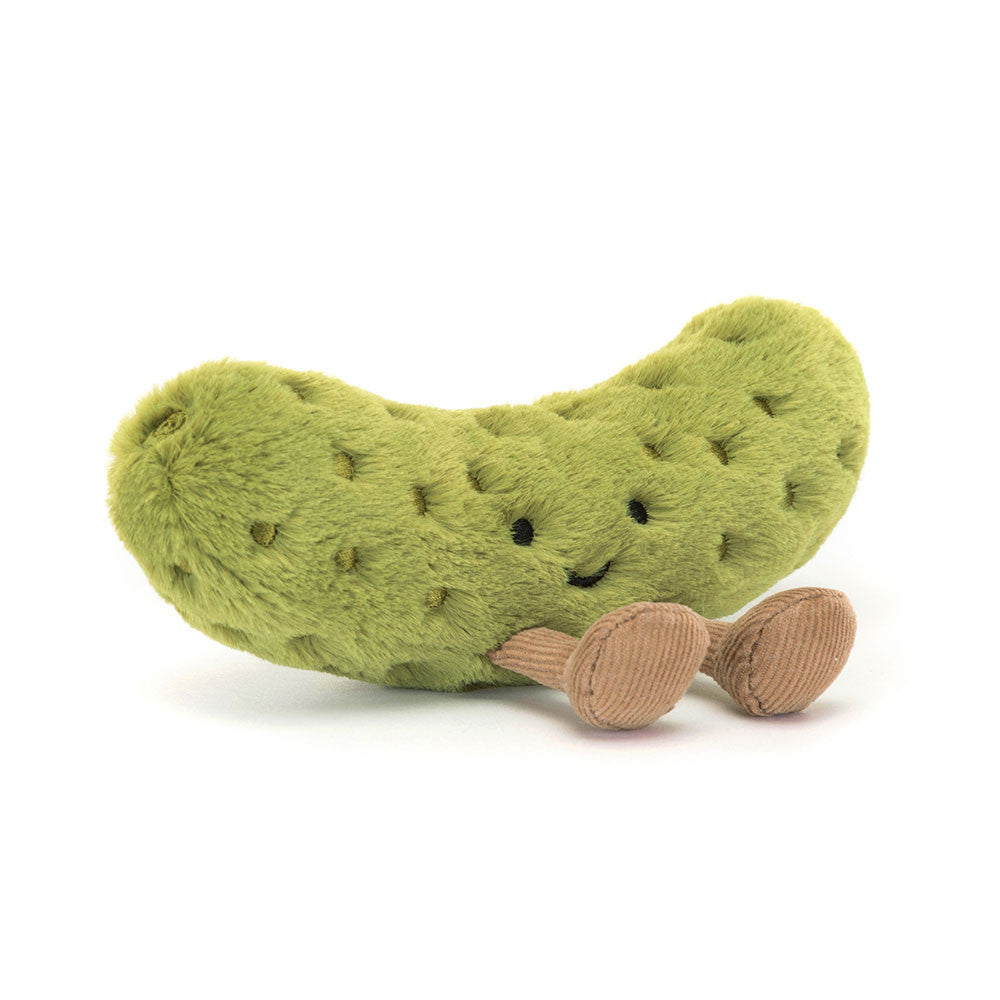 A angled side photo of a plush toy resembling a green pickle with embroidered freckles, nutty cord boots, and a smiling face.