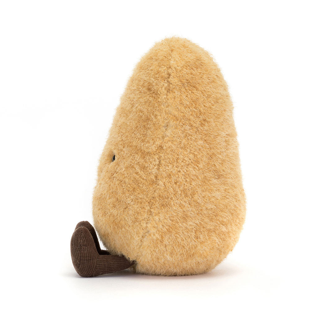A side photo of a plush toy shaped like a potato with a smiling face and brown legs and feet on a white background.