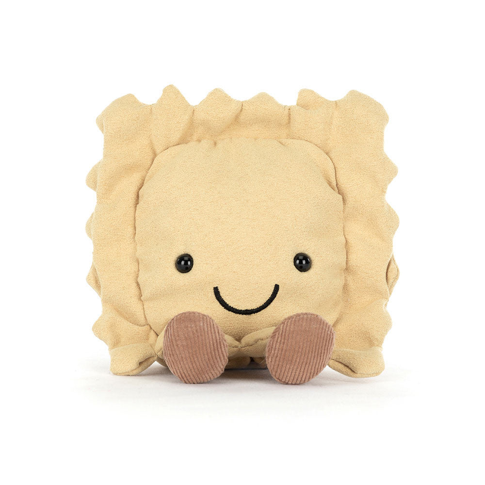 A front facing photo of a plush toy resembling a ravioli pasta with a smiling face, golden beige body, and brown legs on a white backround. 