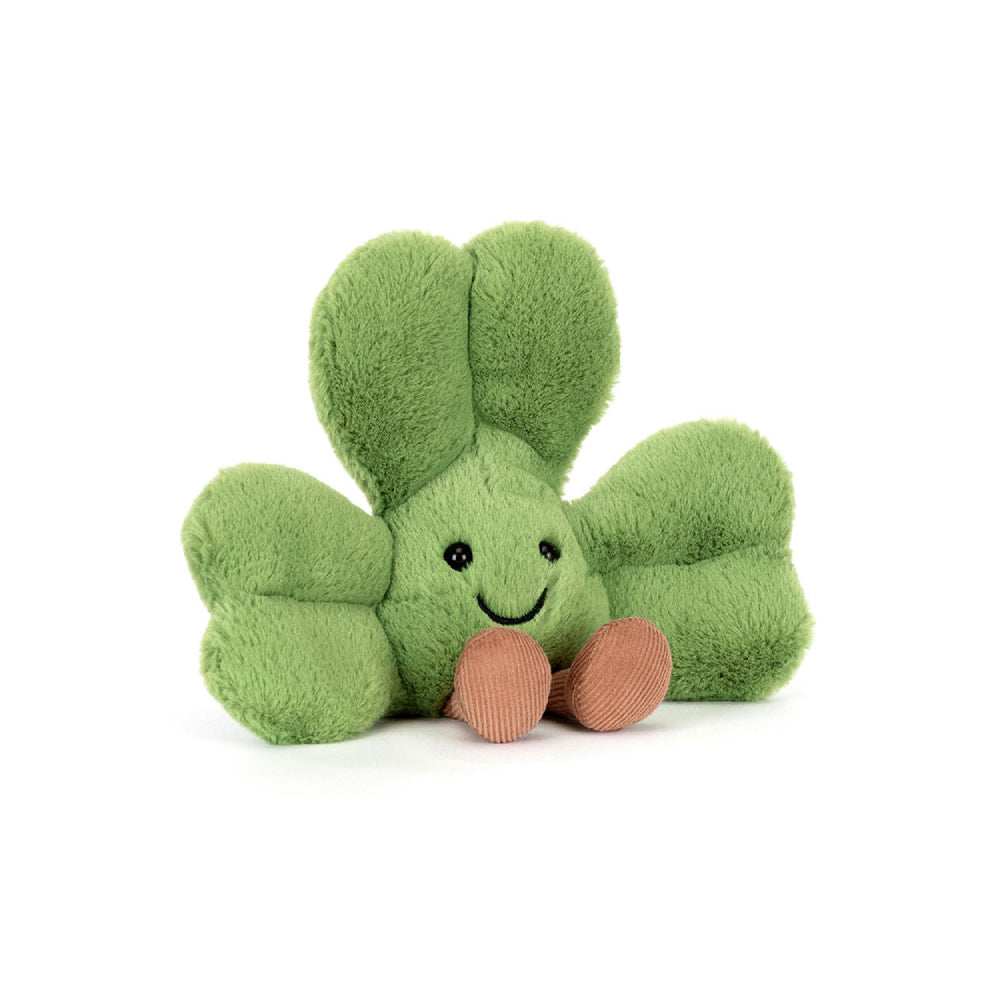 An angled facing photo of a green plush shamrock toy with a happy face on a white background