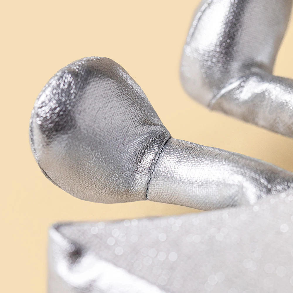 A closeup of a plush silver star's legs in grey colors on a beige background. 