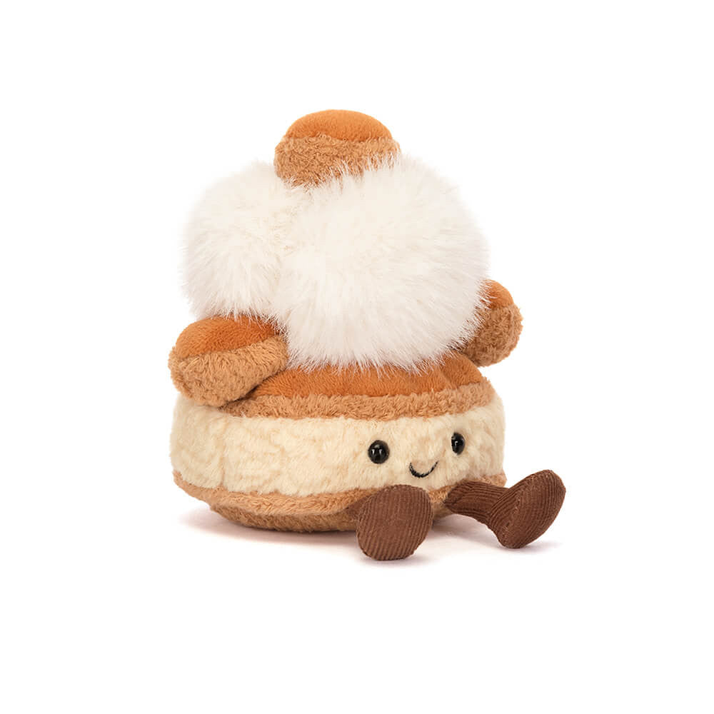 A side angled photo of a push toy resembling a marshmallow with brown and white colors on a white background.