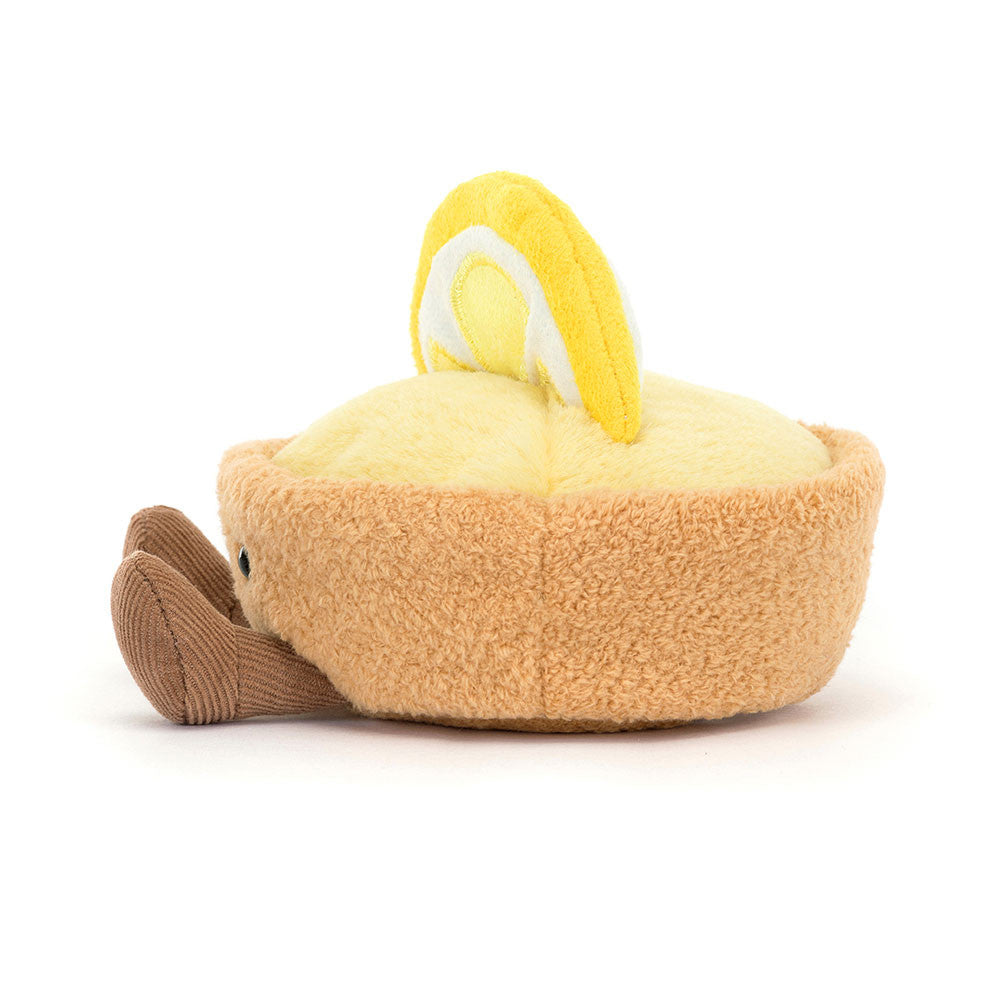 The side of a plush toy resembling a lemon with a smiling face on a white background.