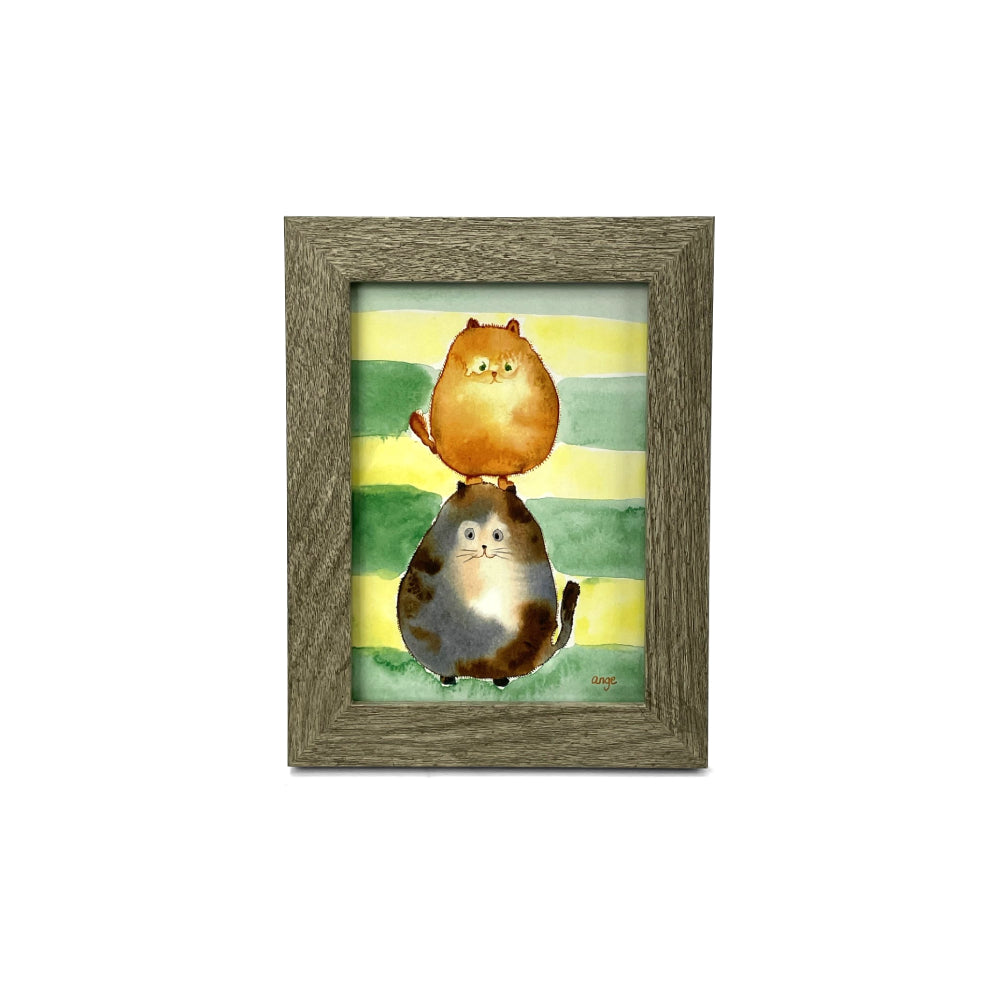 Framed artwork of two cats on a striped background on a white backround.