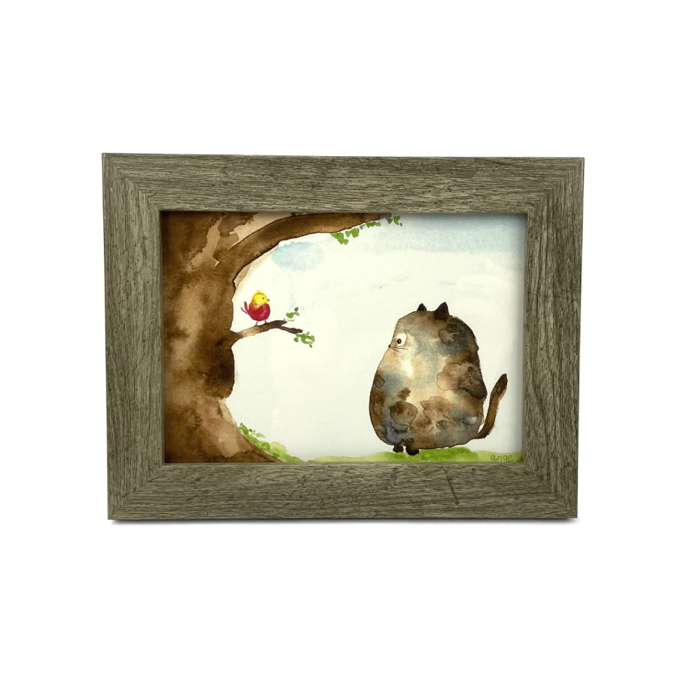 Framed artwork of a cat and a bird by a tree.