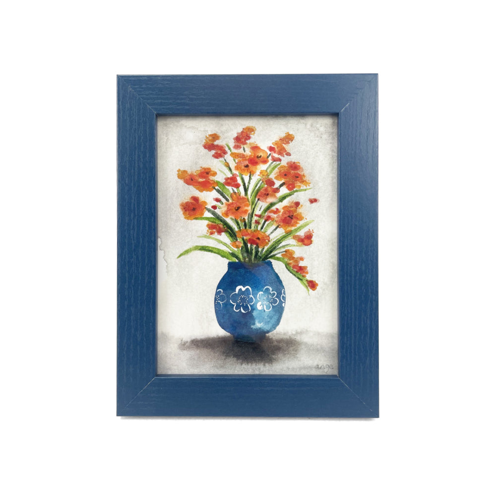 Framed artwork of a blue vase with orange flowers on a white background.