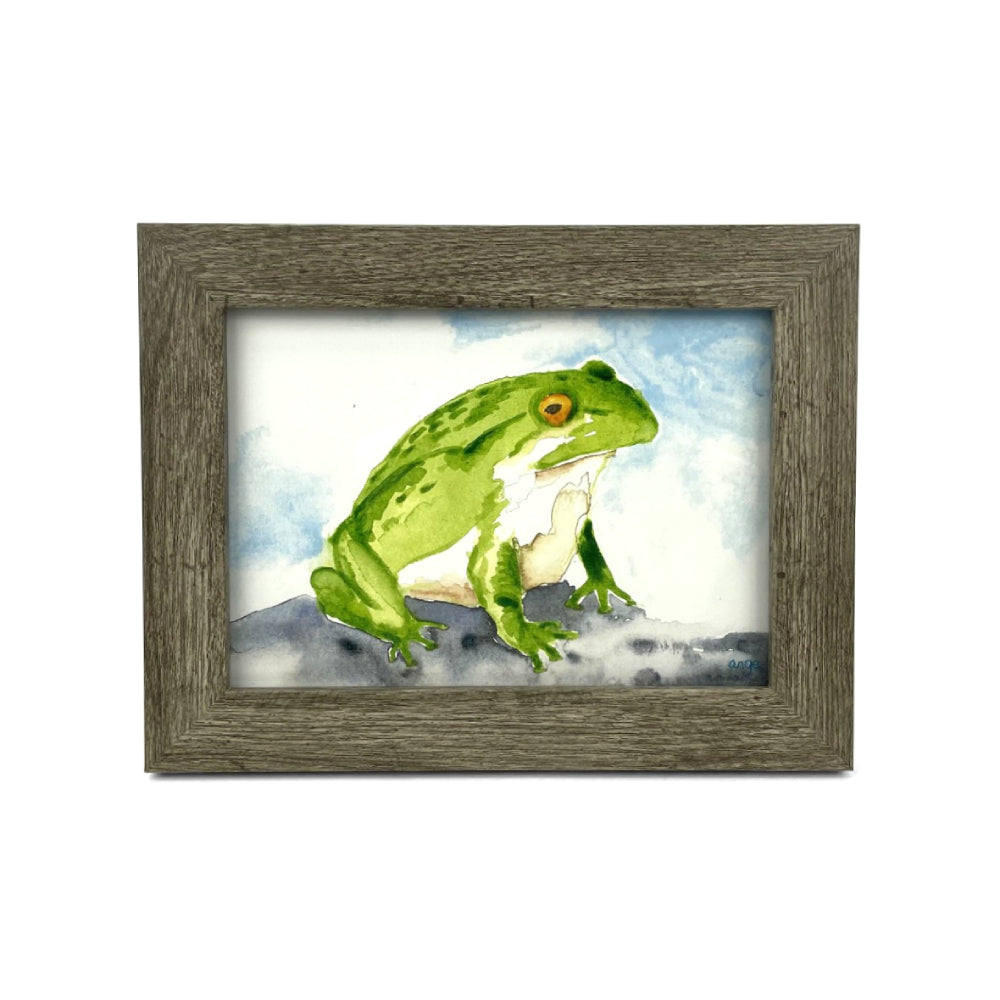 Framed artwork of a green frog on a white background.