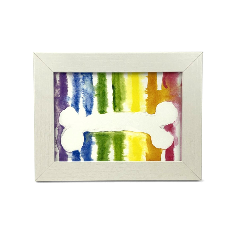 Framed artwork with a colorful abstract stripe design with a white bone outline on a white background.