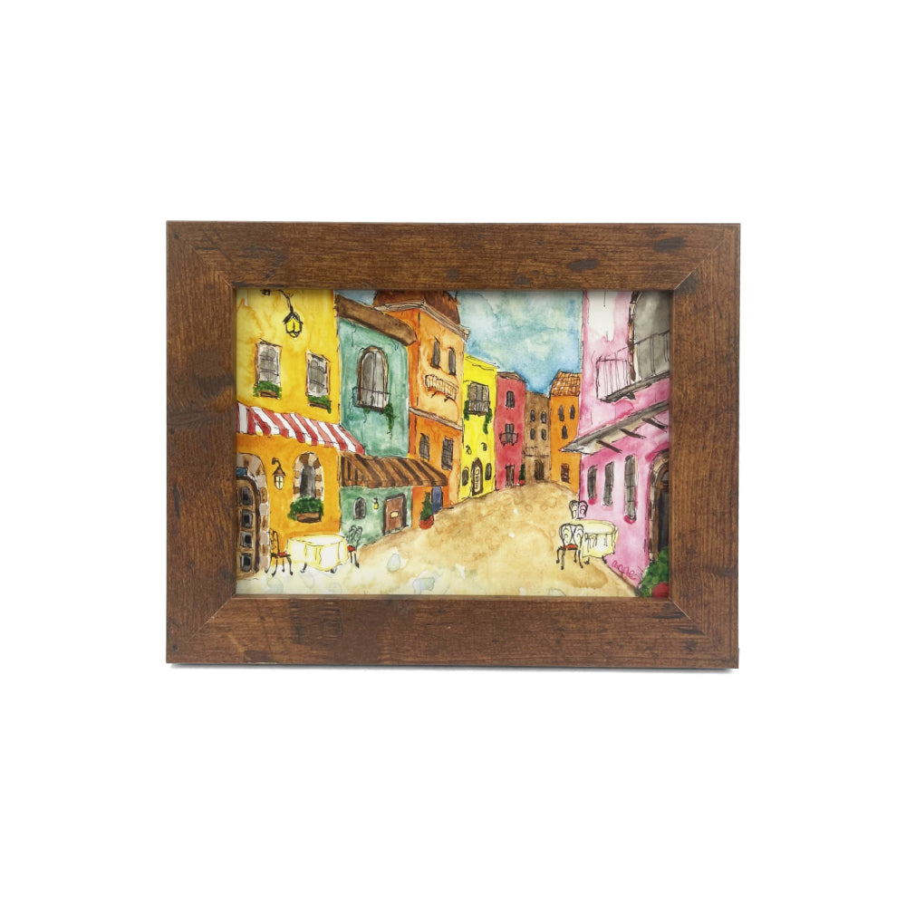 Framed painting of a colorful street scene with buildings and a sidewalk.