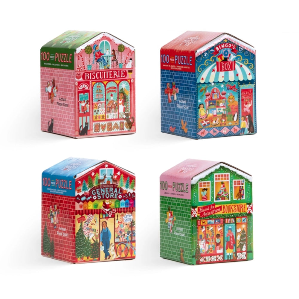 Four small house-shaped puzzle boxes arranged in a 2x2 grid on a white background. Each box is decorated with a different colorful storefront illustration and text including '100 PUZZLE' and shop names such as Biscuitere, Bôt, General Store, and Candy Store.