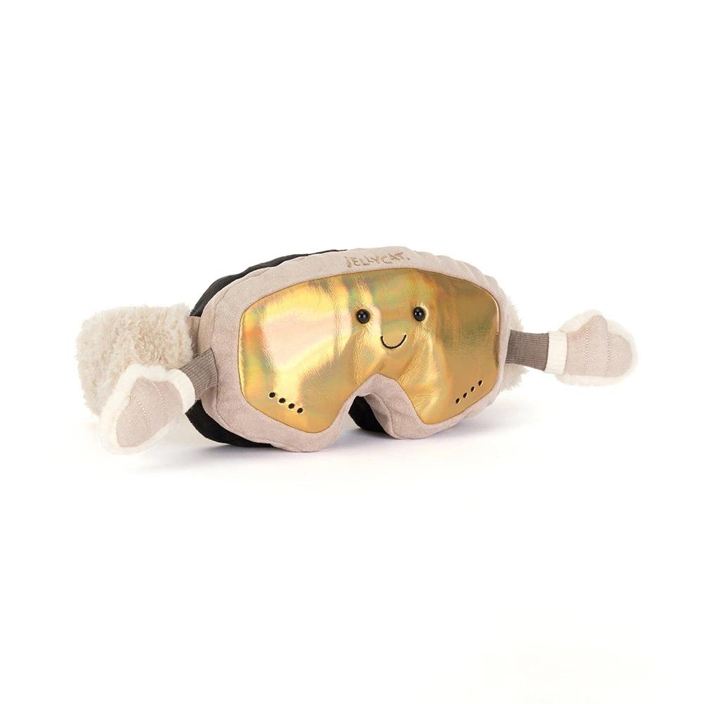 A plush novelty ski goggles with a shiny gold reflective lens, featuring a cute smiling face and fluffy beige faux-fur trim with glove-like extensions on the sides.