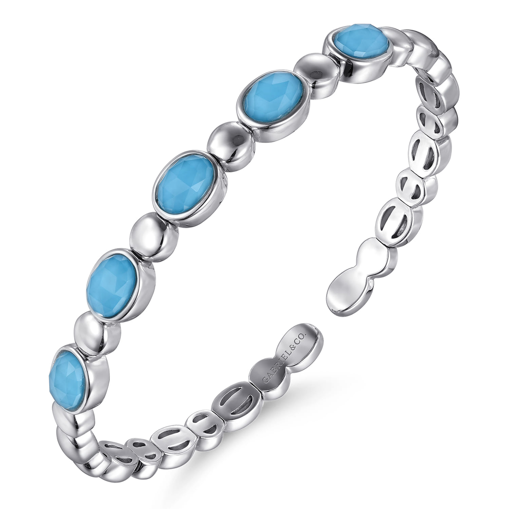 Silver ring with blue gemstones on a white background