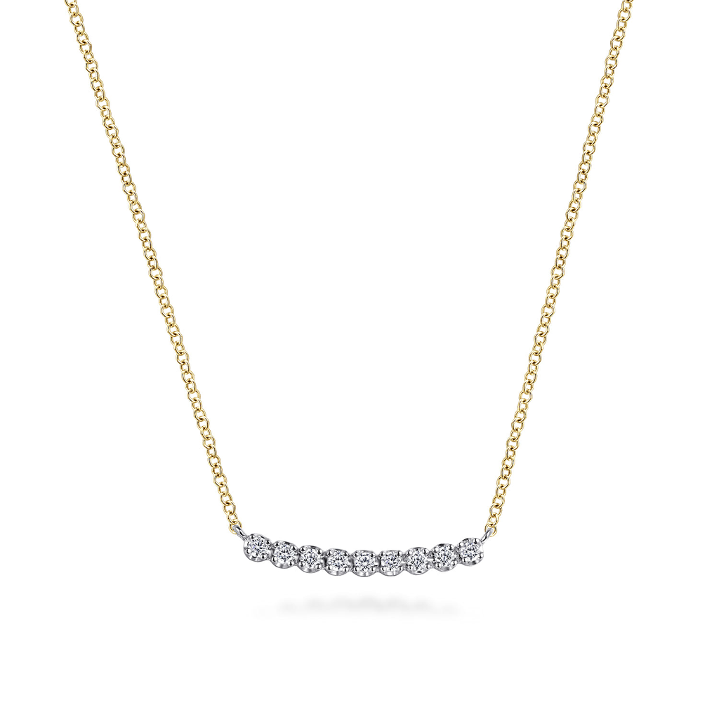 Gold necklace with a small diamond pendant on a white background