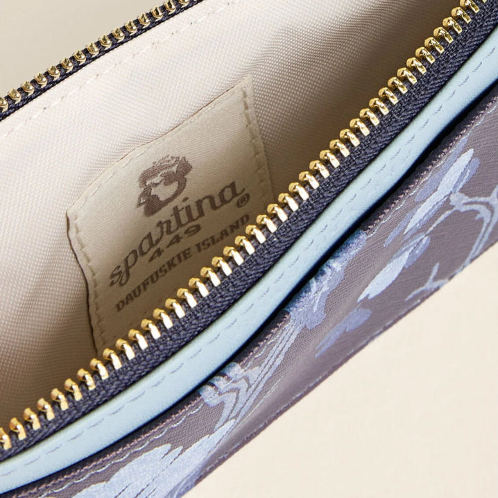 Close-up of a Sparling & Co. Dauphine Valley zip pouch showing the interior lining, gold zipper, and a floral patterned exterior.