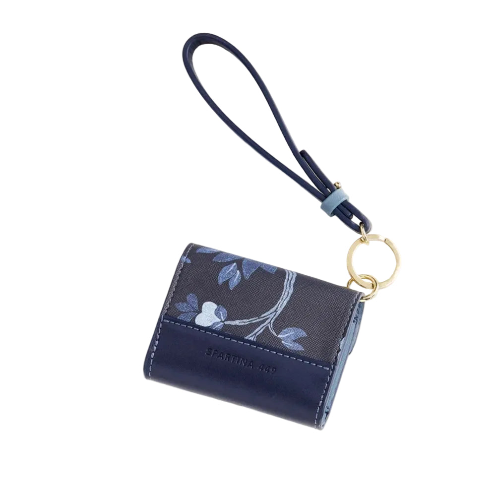 A navy blue leather wallet with a floral patterned front, featuring a matching wrist strap and a gold-tone key ring, shown on a light cream background.