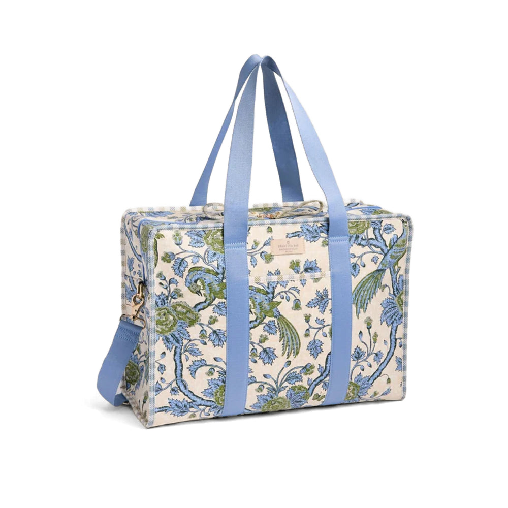 A rectangular duffel bag with a blue and green floral pattern on a cream background, featuring light blue handles and a matching shoulder strap, shown on a white background.