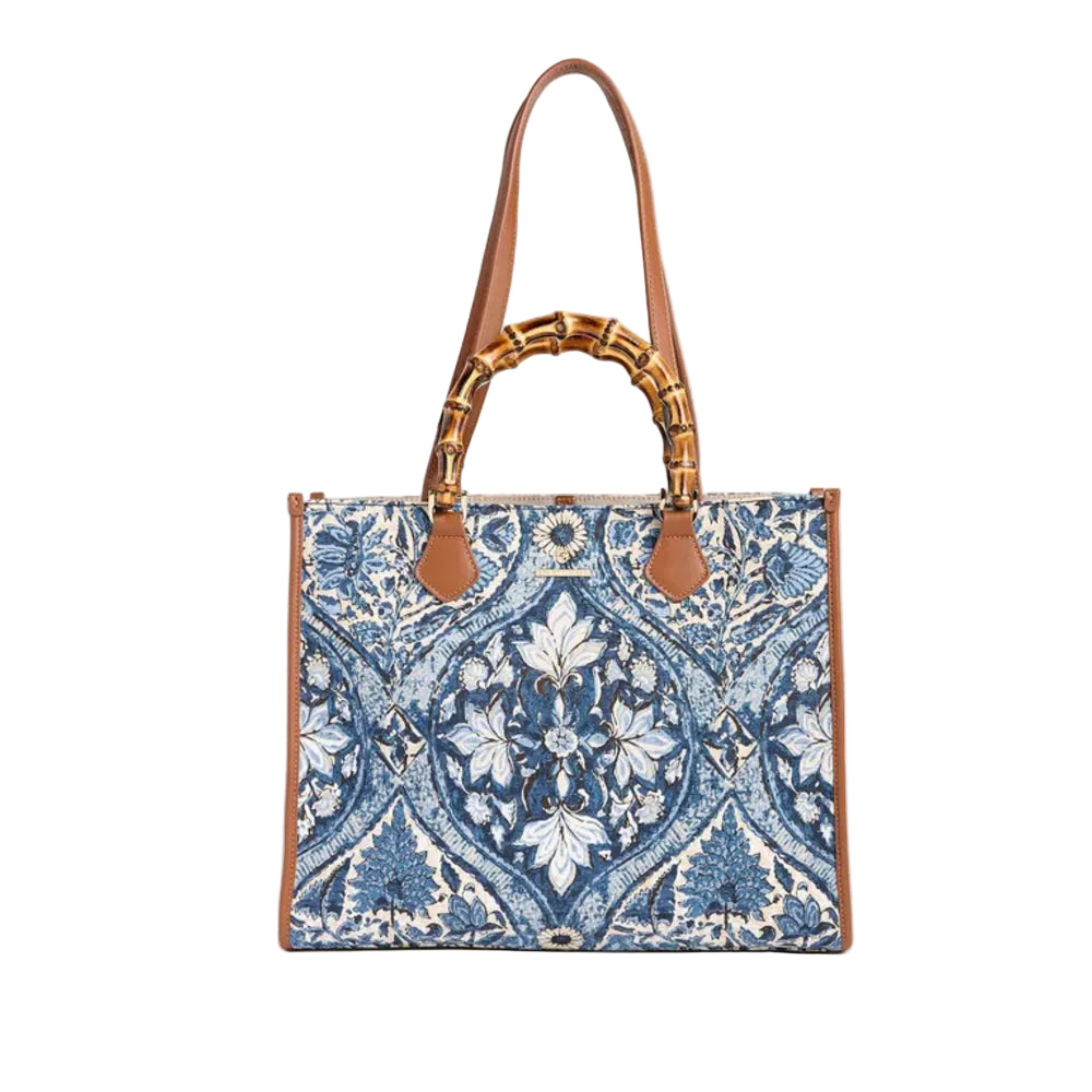 A structured tote bag featuring a blue and white floral damask pattern, brown leather trim, and a faux-bamboo handle, shown against a plain light beige background.