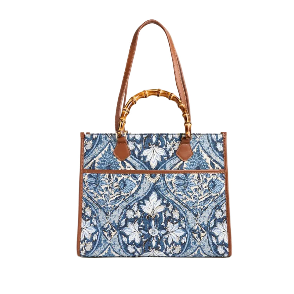 A structured tote bag featuring a blue and white floral damask pattern, brown leather trim, a bamboo-style top handle, and a single shoulder strap, set against a plain off-white background.