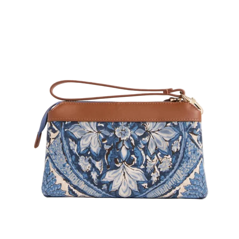 A small wristlet clutch bag with a brown leather trim and strap, featuring a blue and white floral mandala pattern on the body, set against a solid light beige background.