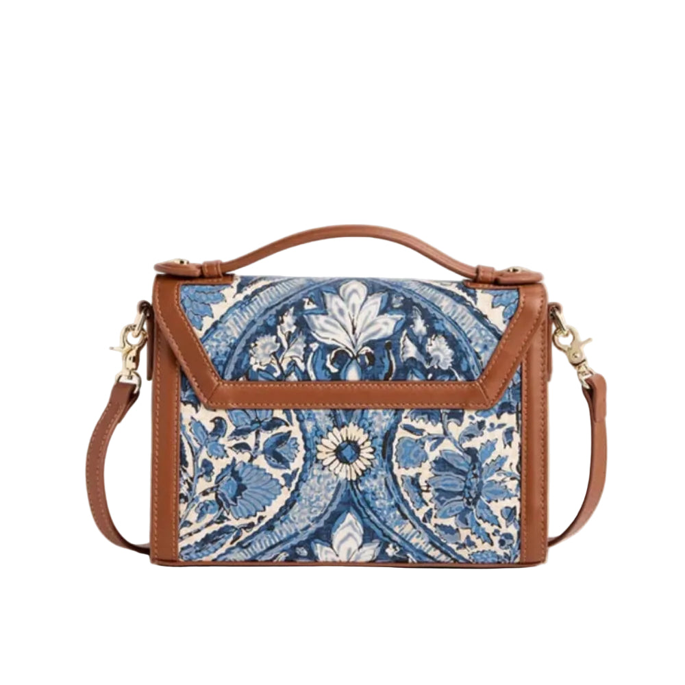 A structured handbag with a blue and white floral tapestry front panel, brown leather trim, a top handle, and a detachable shoulder strap, shown on a plain white background.
