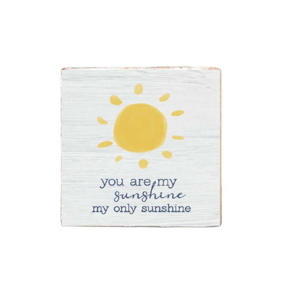 White wooden square block sign with a sun illustration and text 'you are my sunshine, my only sunshine' on a white  background.